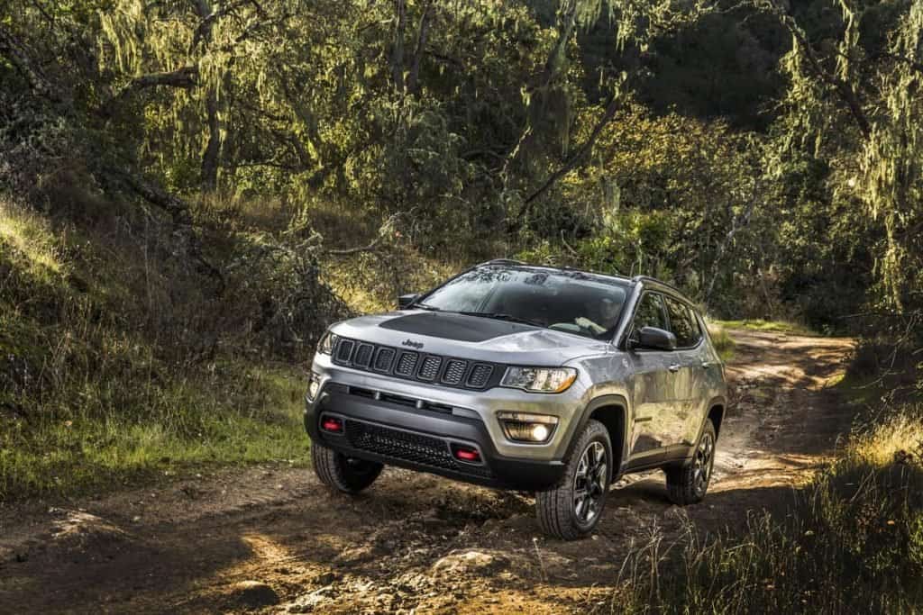 Jeep Compass image for "which Jeep models should I avoid?" shows a grey Jeep Compass traversing tough terrain