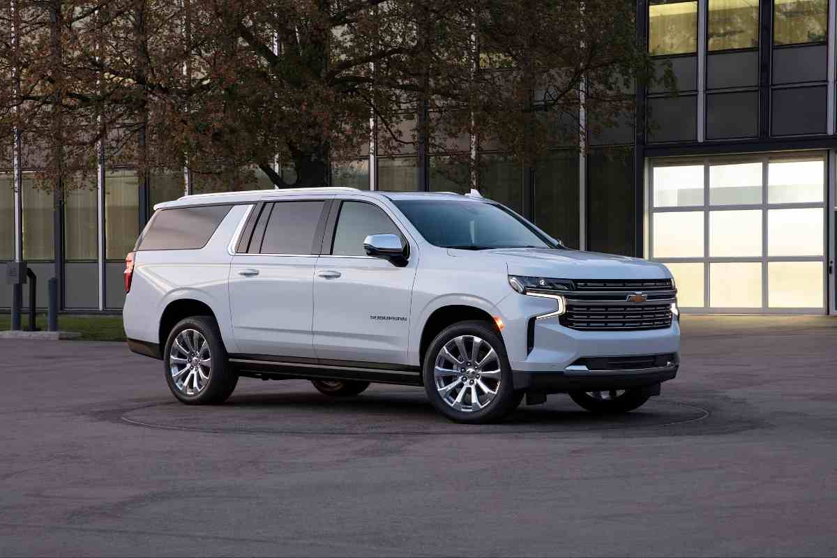 Image for: "can you flat tow a  chevy suburban?" shows a white chevy suburban in front of an urban environment