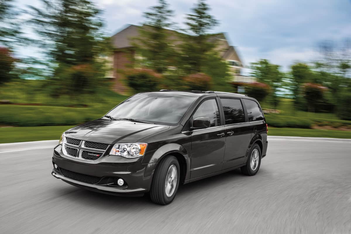 Image for: Sleeping in a Dodge Caravan shows a dark gray Dodge Grand Caravan driving at speed
