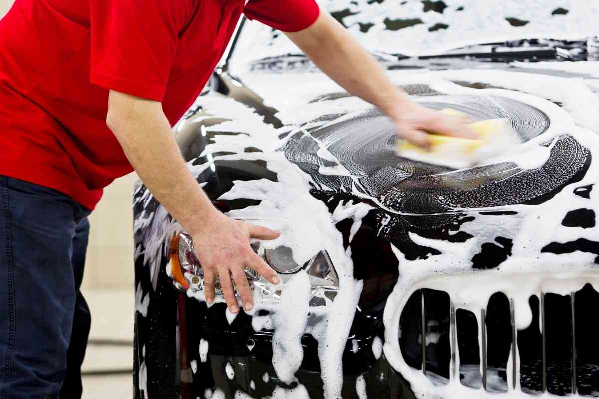 A man washing a car with a sponge
