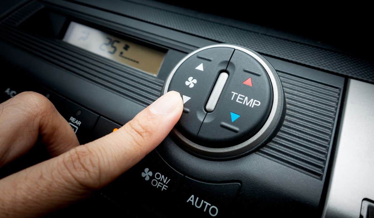 Finger on Fan switch of a Car air conditioning system