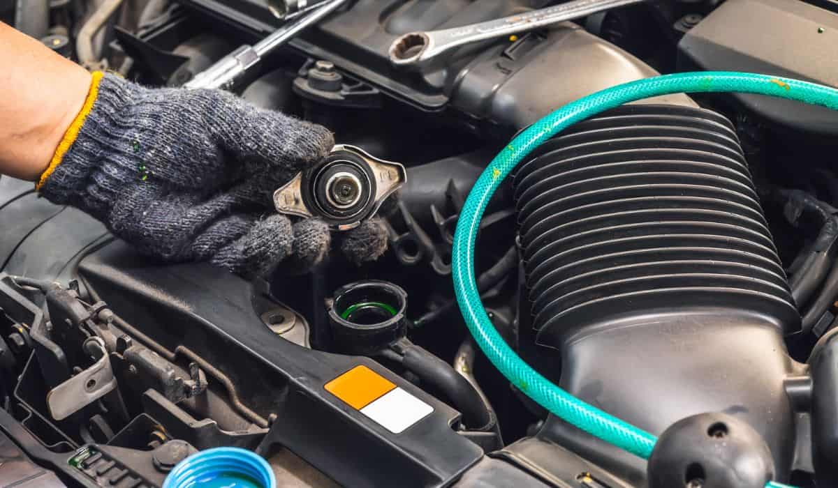 Hand of Mechanic check water in car radiator and add water antIfreeze coolant fluid to car radiator at garage