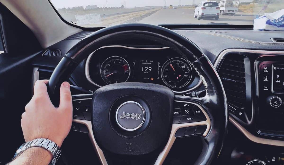 A Person in Denim Pants Controlling the Steering Wheel of a Vehicle