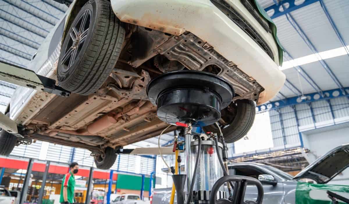 A car that comes to change the engine oil in Car repair station paved with epoxy floor and electric lift