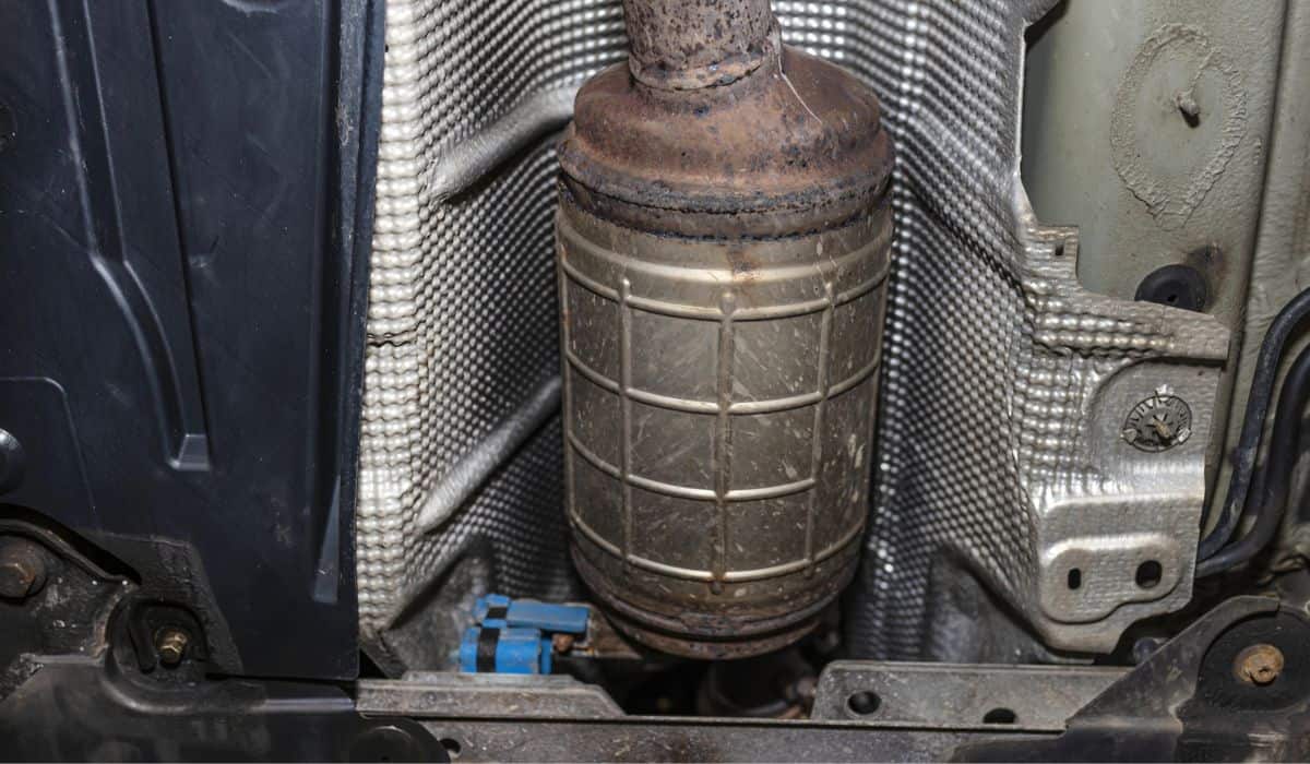 A diesel particulate filter in the exhaust system in a car on a lift in a car workshop