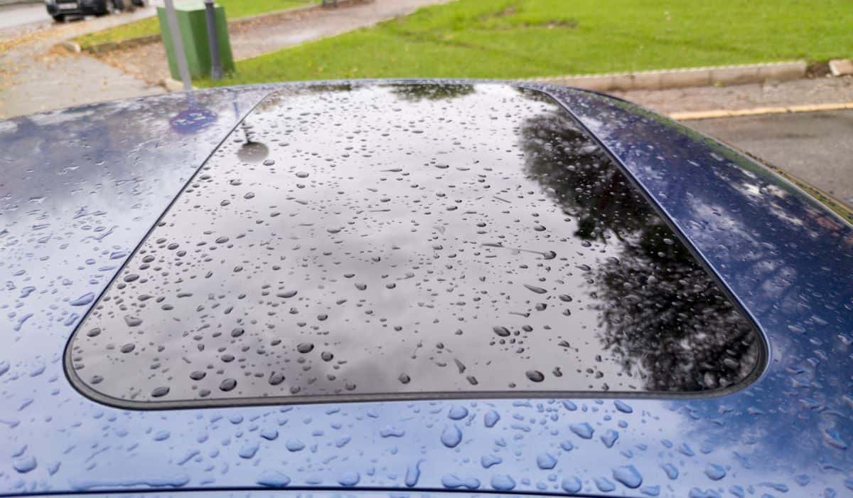 Car sunroof covered with thick rain drops