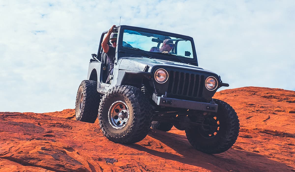 Jeep Wrangler going over red dirt cliff 