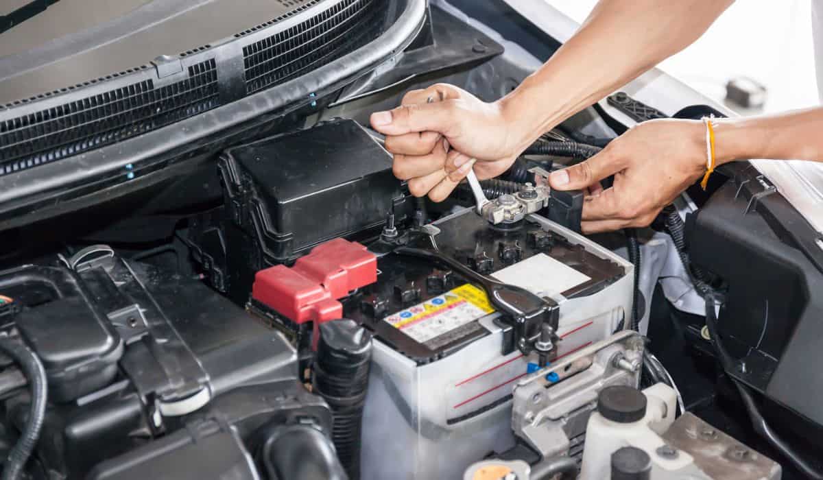 Mechanic engineer fixing car battery in garage