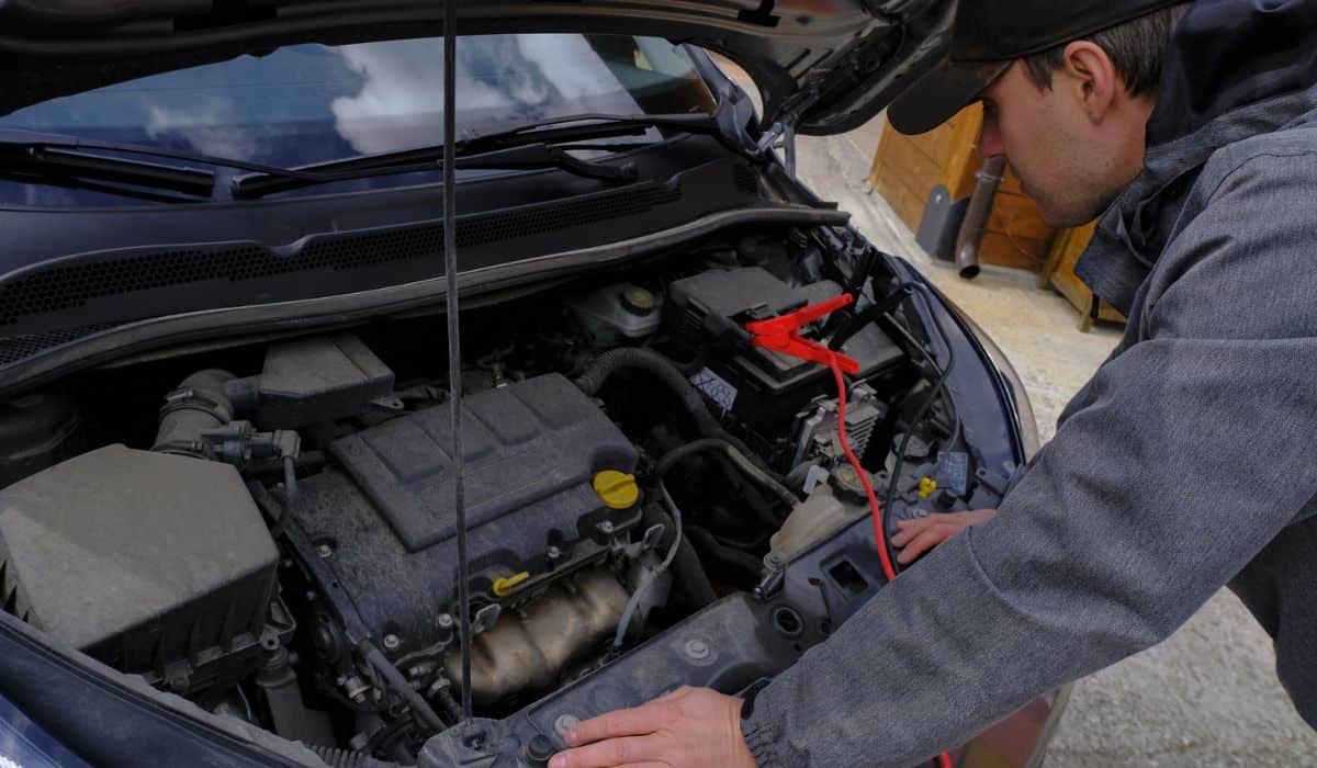 Mechanic in working clothes looking and fixing car