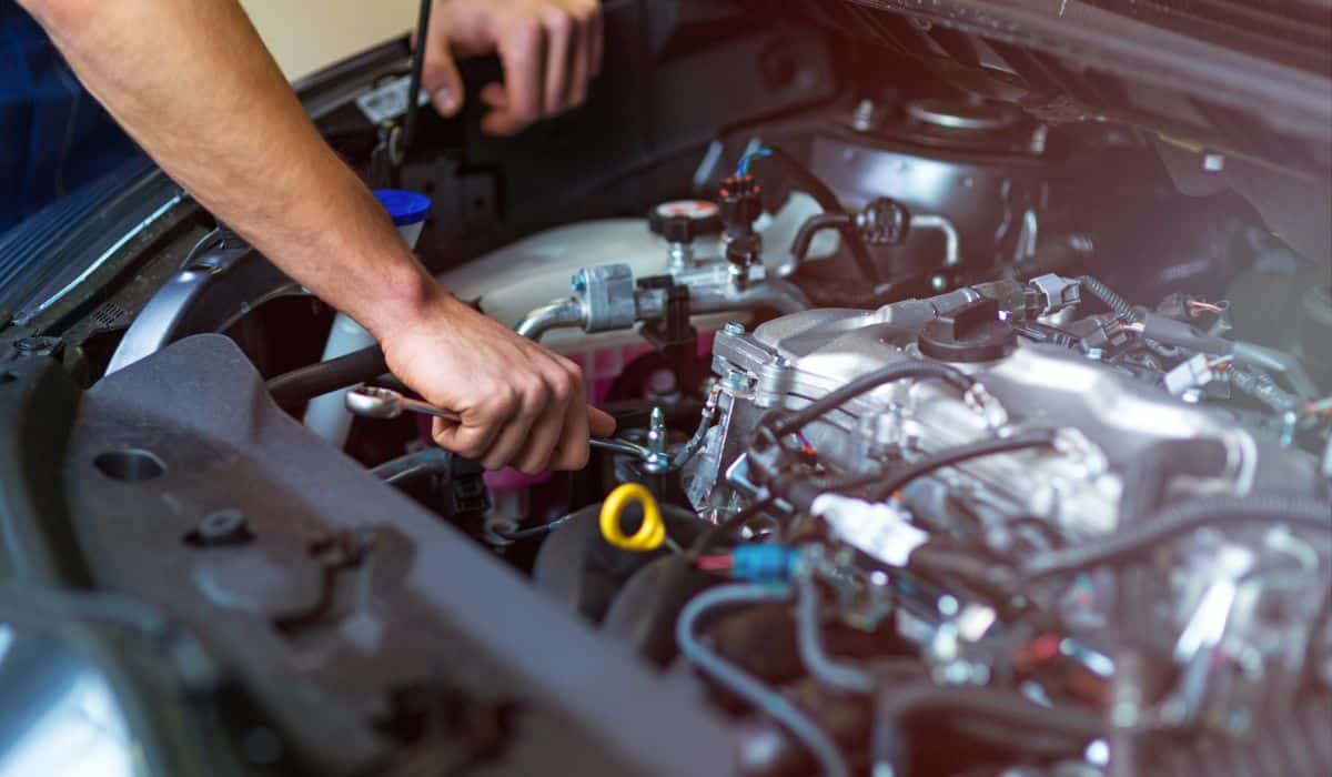 Mechanic working on car engine in auto repair shop