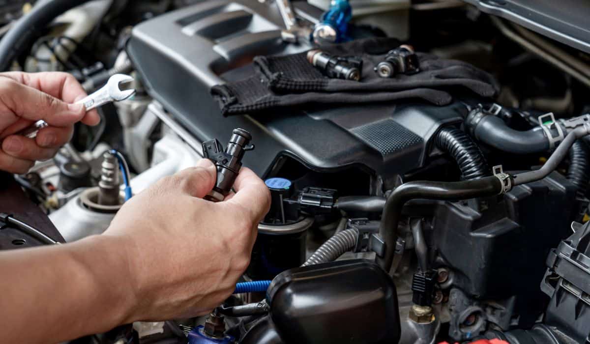 Technician Removing the gasoline injector part in engine room check dust and test pressure