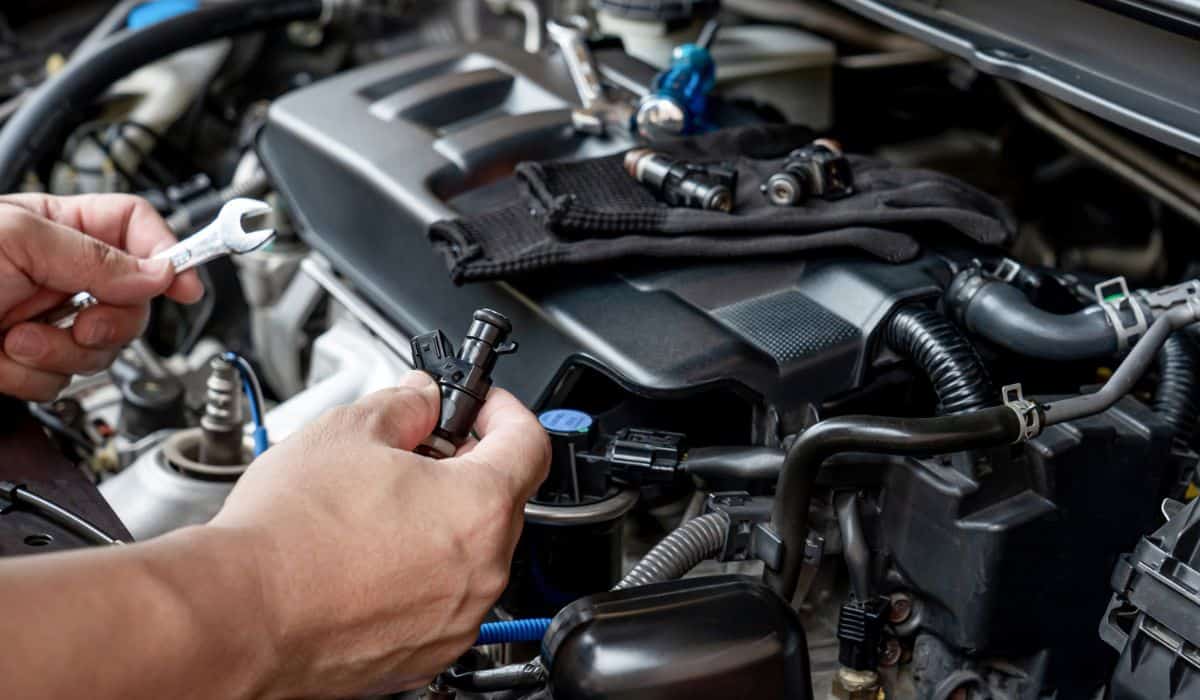 Technician Removing the gasoline injector part in engine room check dust and test pressure