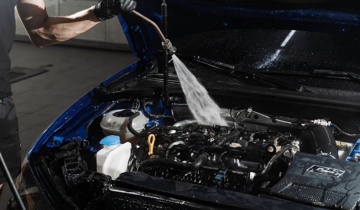 Washing car engine with with water in detailing auto service