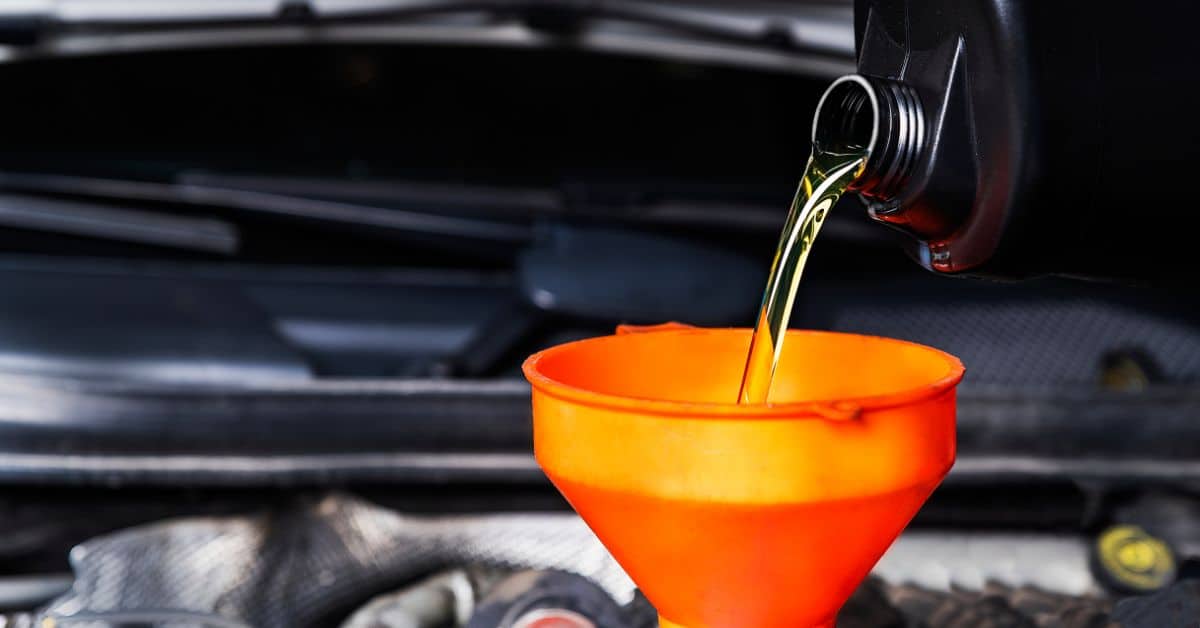 Image for oil and oil filter change: shows oil being poured into a funnel over an engine