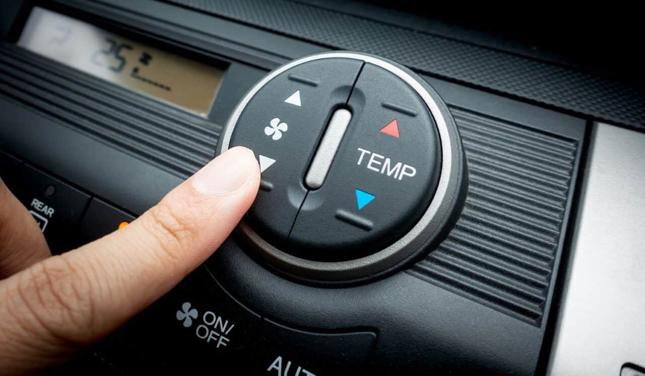 Finger on Fan switch of a Car air conditioning system