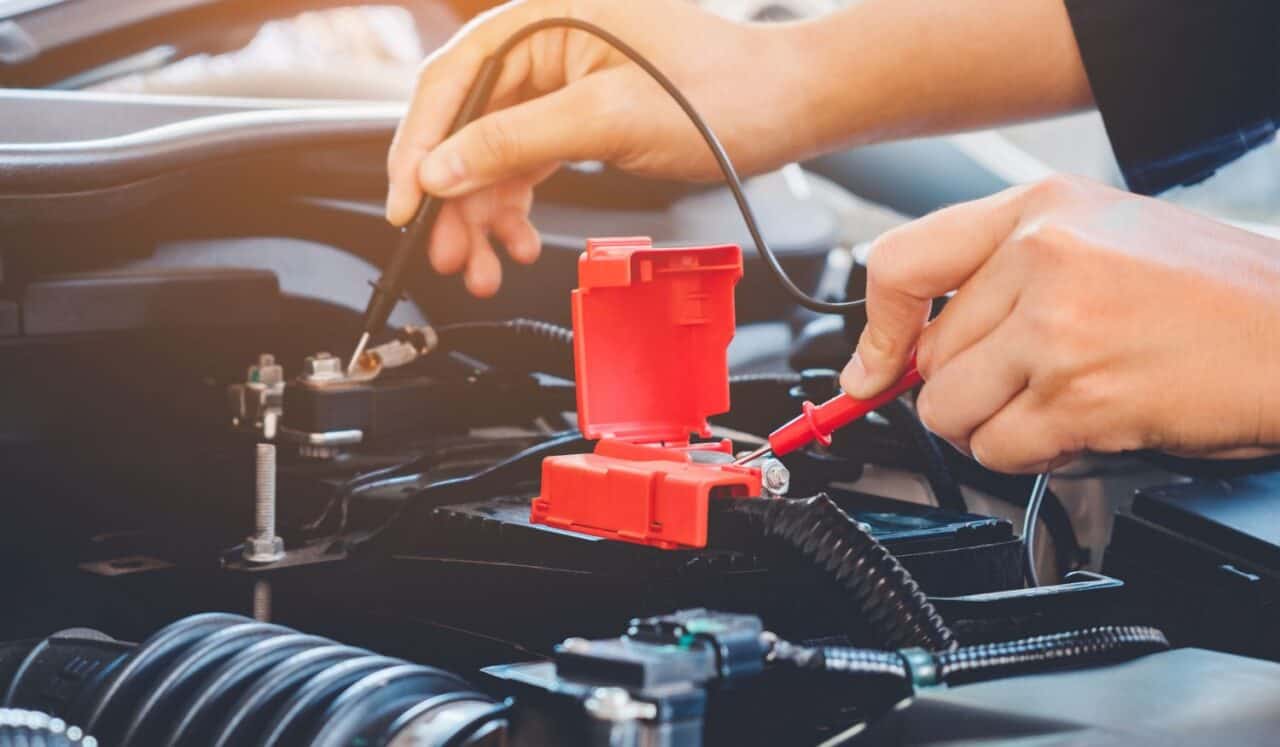 Hands check battery car mechanic working in auto repair service