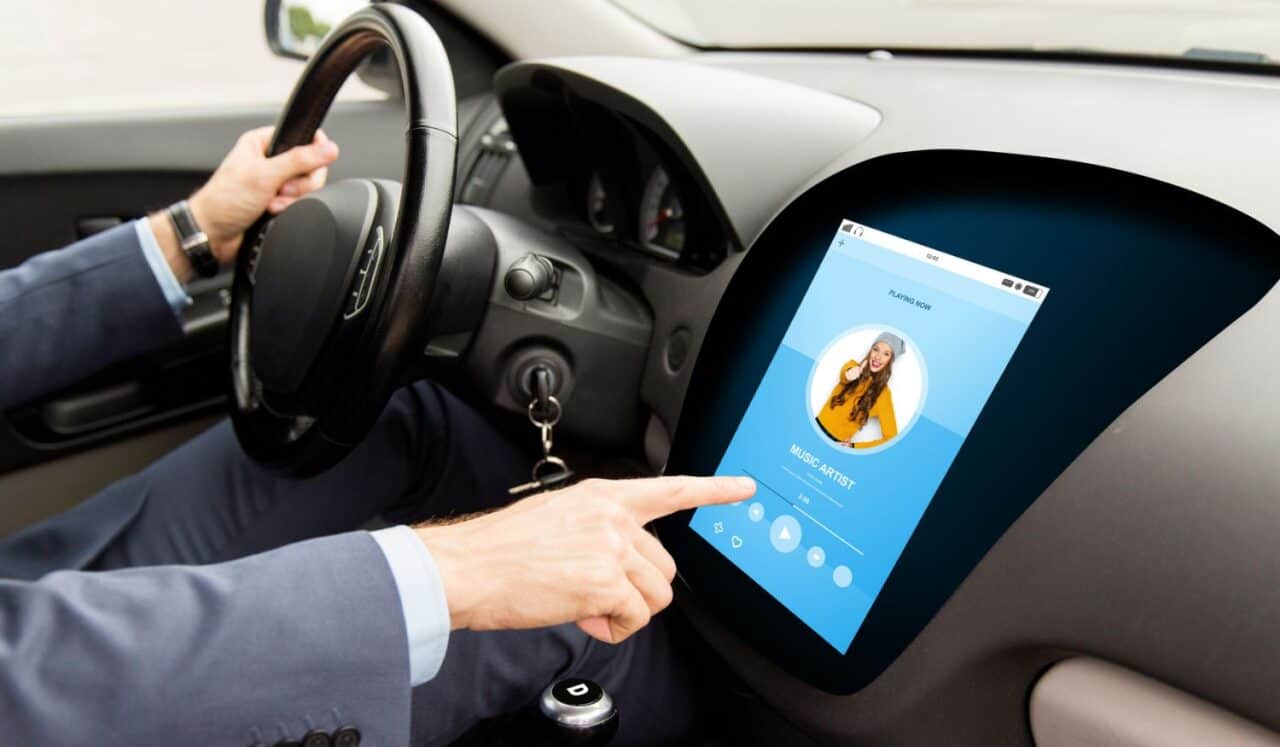 Man driving car with music on board computer