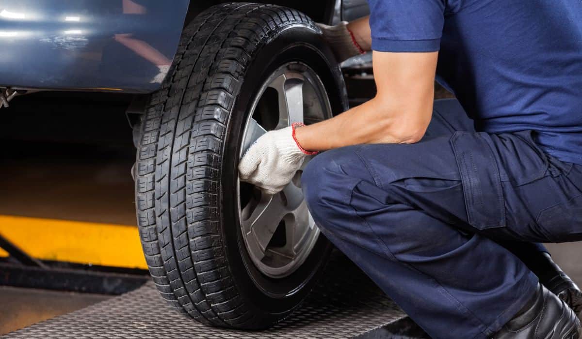 Mechanic Fixing Car Tire At Repair Shop