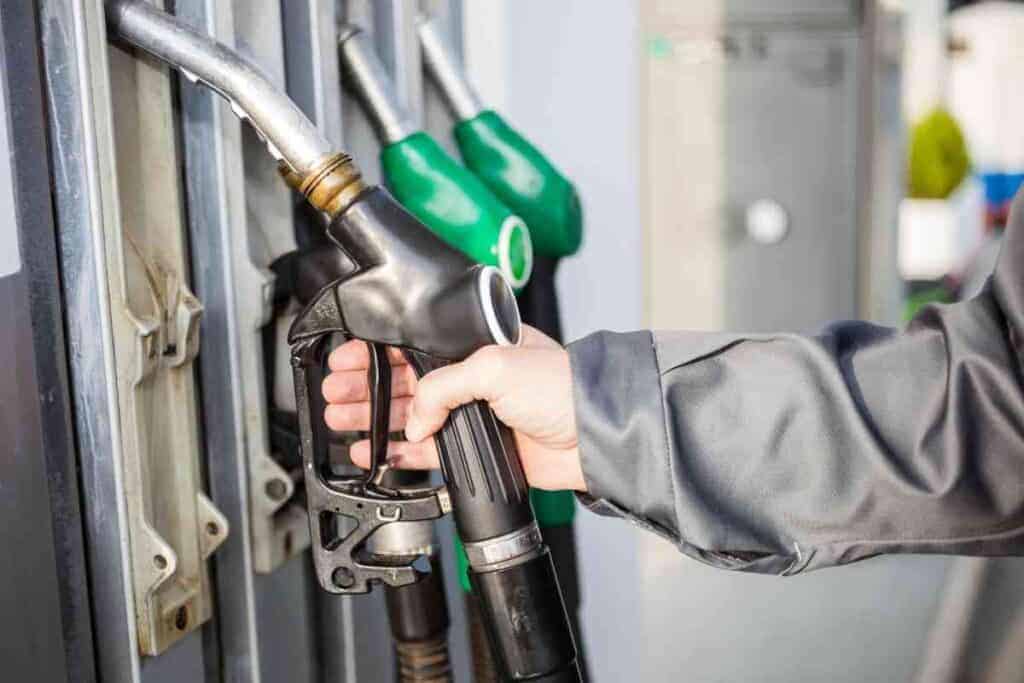 A generic image of a hand taking a fuel pump off the holster for the article: which SUVs use regular gas
