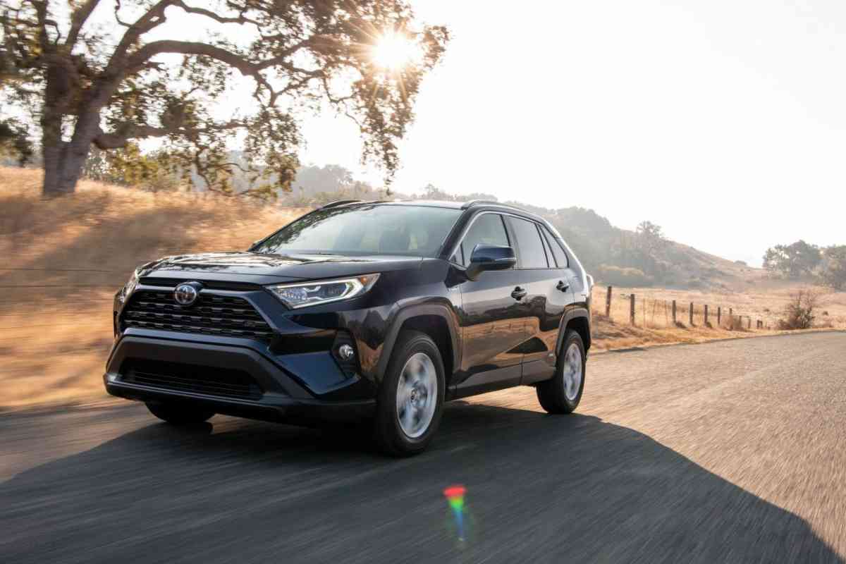 How Does The RAV4 Hybrid work? An image shows the Toyota Rav4 Hybrid against a highway and mountainous background