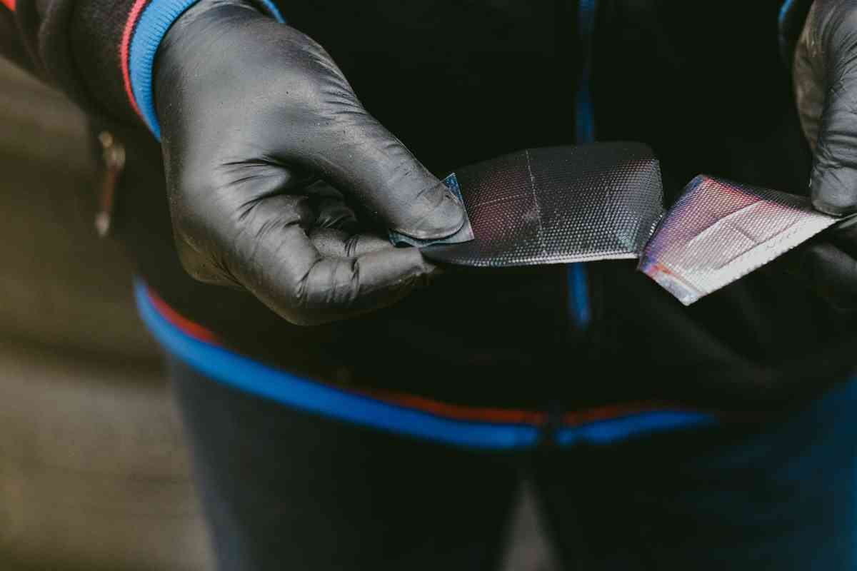 Image for "Cost of tire patch" shows a mechanic's hand peeling a patch, wearing protective gloves