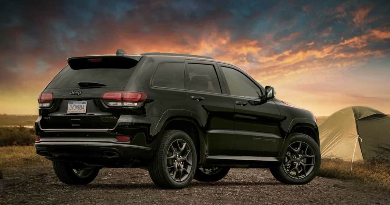 Image for: worst jeep grand cherokee years to avoid. The image shows a black 2020 Jeep Grand Cherokee against a sunset. 