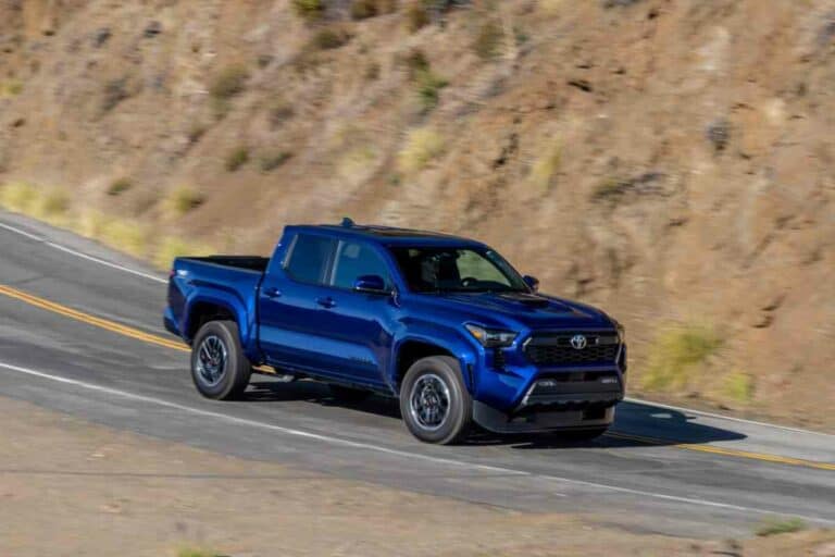 106,000 Toyota Tacomas Recalled Over Brake Hose Flaw (2024-2025 Models) 1 photo of a blue toyota tacoma TRD Pro driving through the mountains
