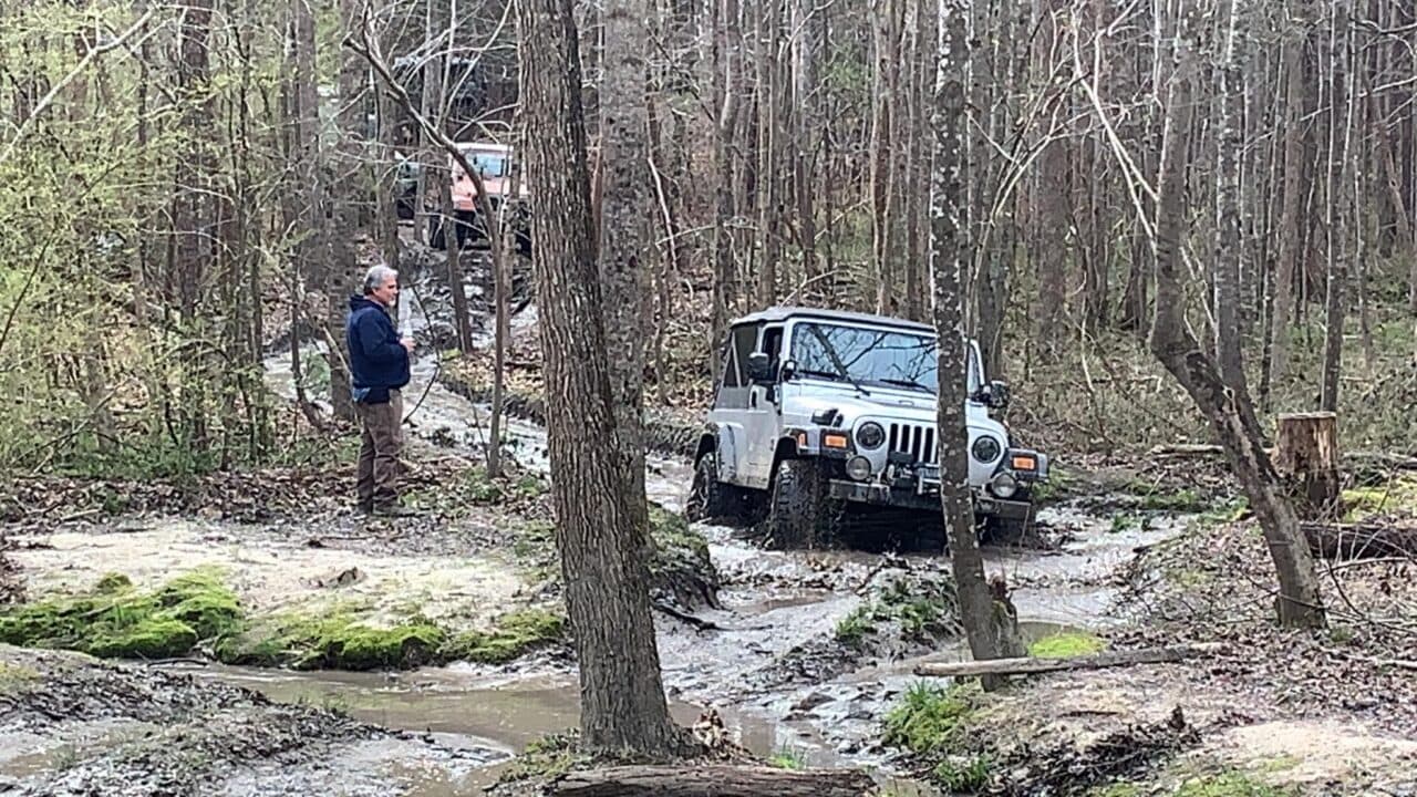 photo of a Jeep Wrangler LJ offroading on a muddy trail