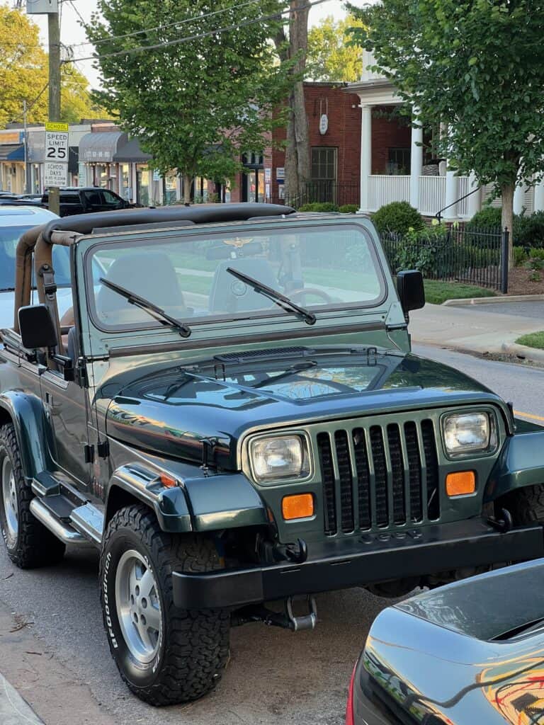 photo of a 1993 Jeep Wrangler YJ parked along the side of a neighborhood street