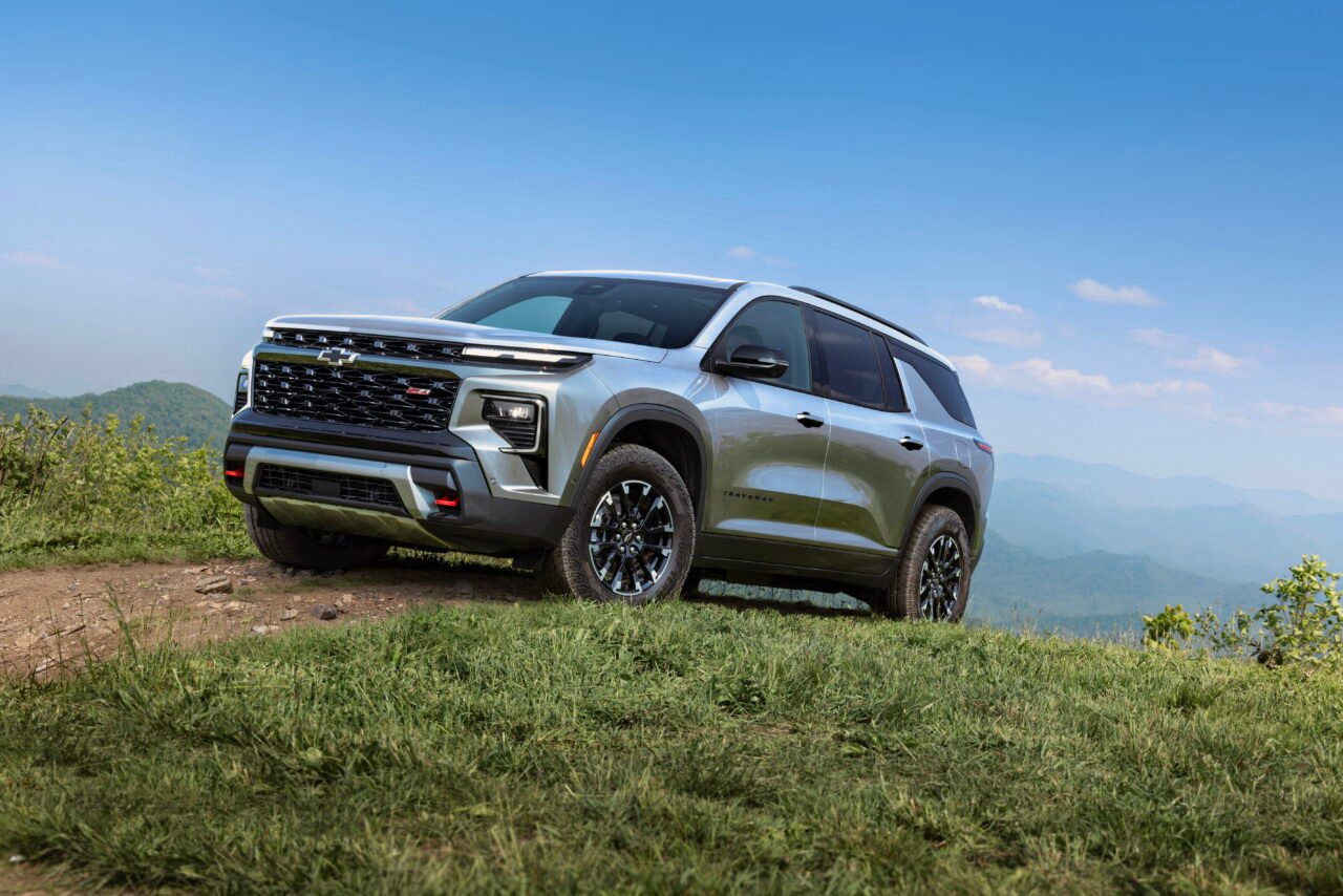 Front 3/4 view of 2025 Chevrolet Traverse Z71 in Sterling Gray Metallic driving up a grassy hill. Preproduction model shown. Actual production model may vary. Available starting early 2024