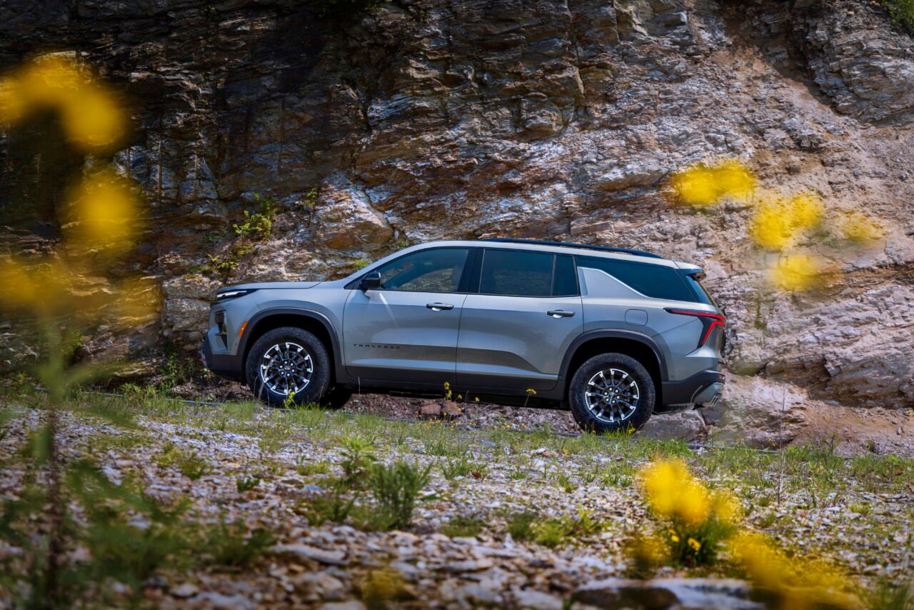 Driver’s side profile view of 2024 Chevrolet Traverse Z71 in Sterling Gray Metallic driving on a mountain road. Preproduction model shown. Actual production model may vary. Available starting early 2024.