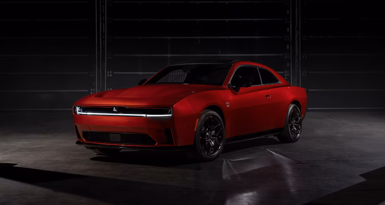 The Dodge Charger Multi-Energy Lineup Wins Car Of The Year Award Despite Slow Sales 1 Dodge Charger Multi-energy Lineup image showcases a red Dodge Charger EV in a dark room, with an industrial background